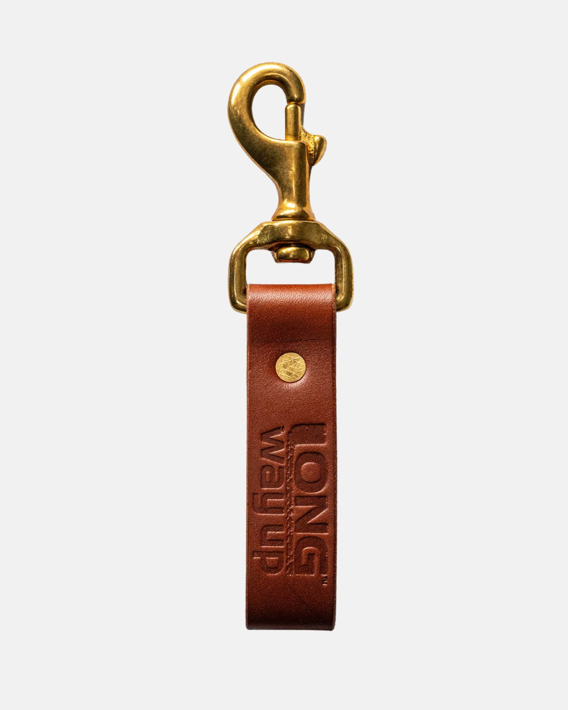 The Long Way Shops Long Way Up Lanyard features a brown leather strap embossed with LONG WAY UP, a brass swivel clasp, and a gold rivet, all shown against a plain white background.