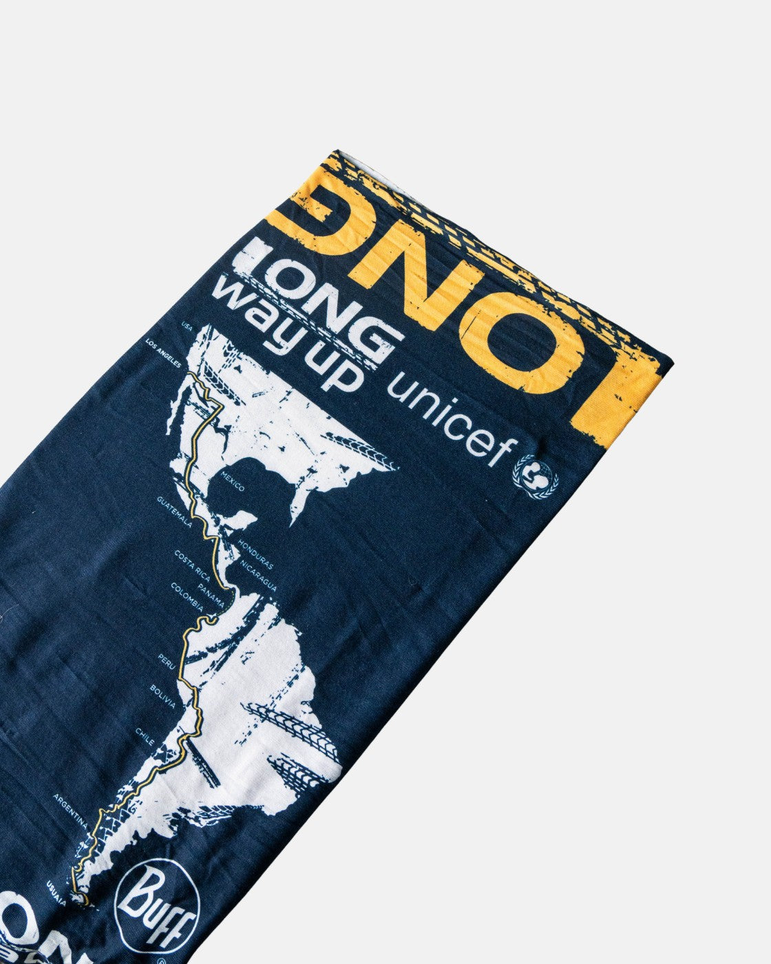 The Long Way Up Neck Buff by Long Way Shop features navy blue fabric with yellow and white LONG WAY UP and unicef text, a printed map of South America, and a Buff logo, displayed flat on a white background.