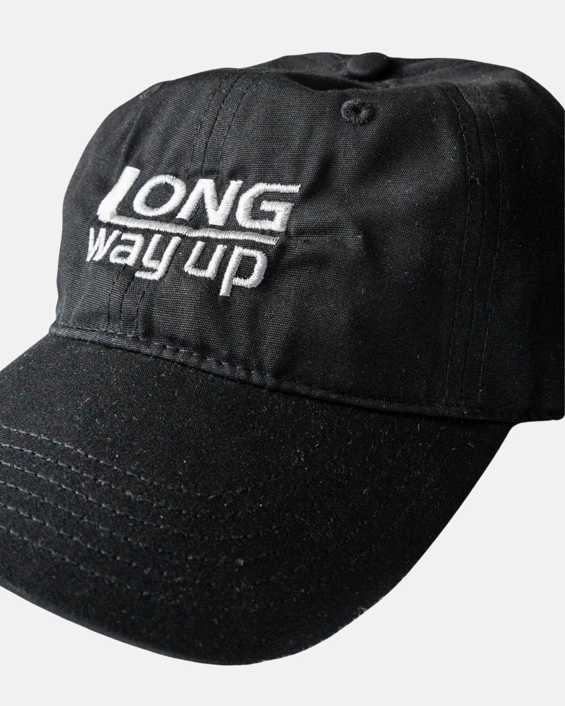 The Long Way Shops Long Way Up Black Cap features white embroidered LONG way up text on the front.