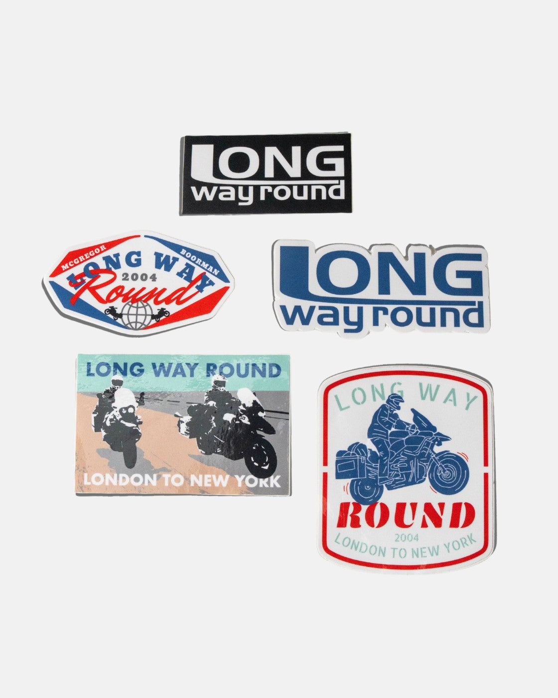 The Long Way Shop’s Long Way Round Sticker Pack includes five stickers featuring motorcycles, riders, and logos with phrases like London to New York and 2004, all arranged on a white background.