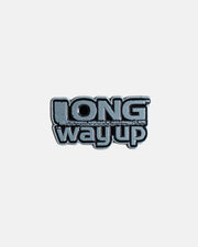 The Long Way Shops Long Way Up Pin Badge features bold, stylized text reading LONG way up on a sleek metallic pin, set against a plain light gray background.