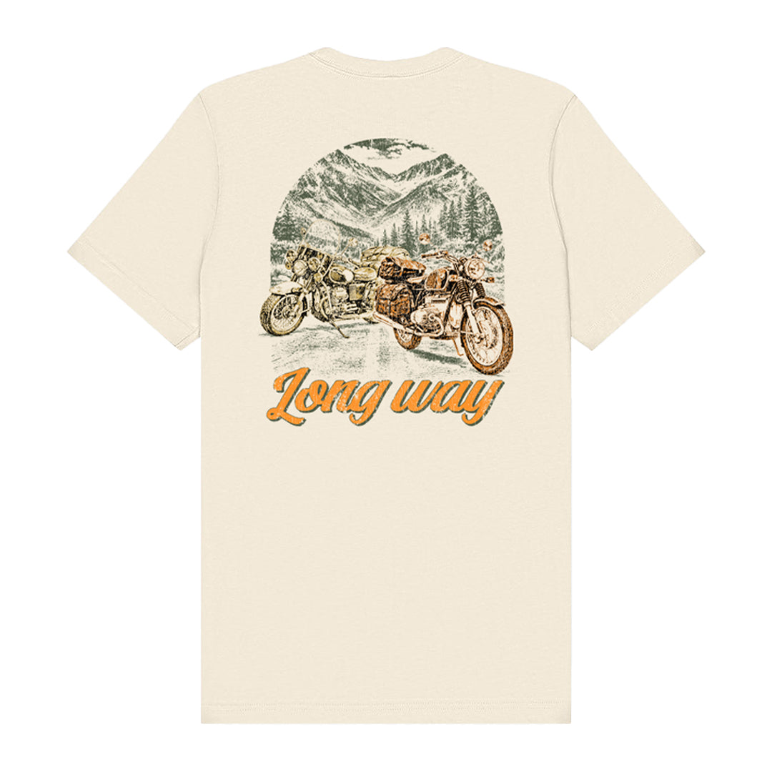 The Long Way Shop’s Long Way Bike Mountain Natural T-Shirt is a cream-colored unisex tailored fit tee crafted from soft Airlume combed cotton. It features a high-quality DTG-printed illustrated design of two motorcycles on a mountain road lined with pine trees, with “Long way” written in orange script beneath the image, offering lasting comfort and vibrant detail.