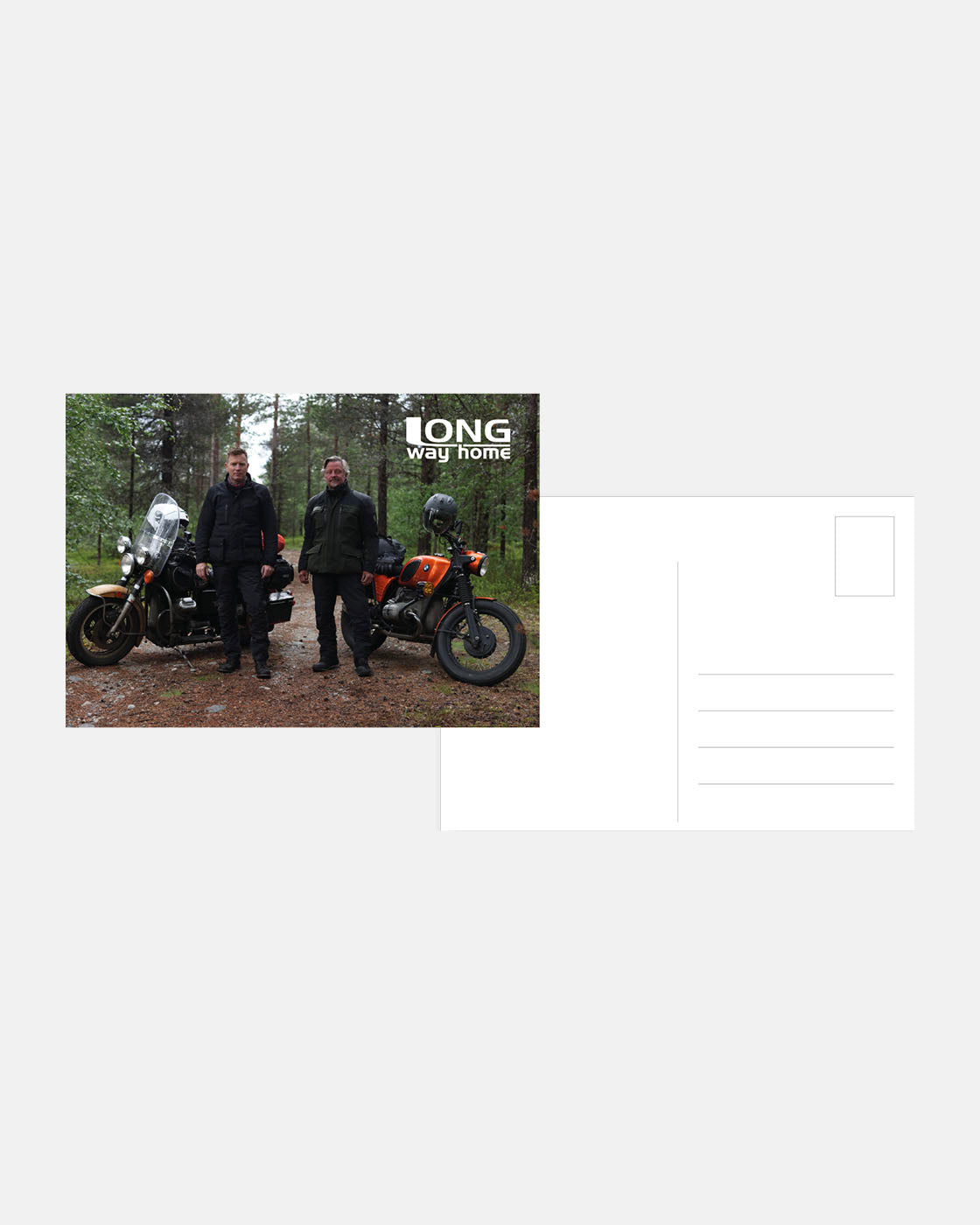 Two riders in gear stand by their motorcycles on a forest road. LONG way home appears at the top right. This Long Way Shop Postcards design is shown on the left side of a blank postcard template.
